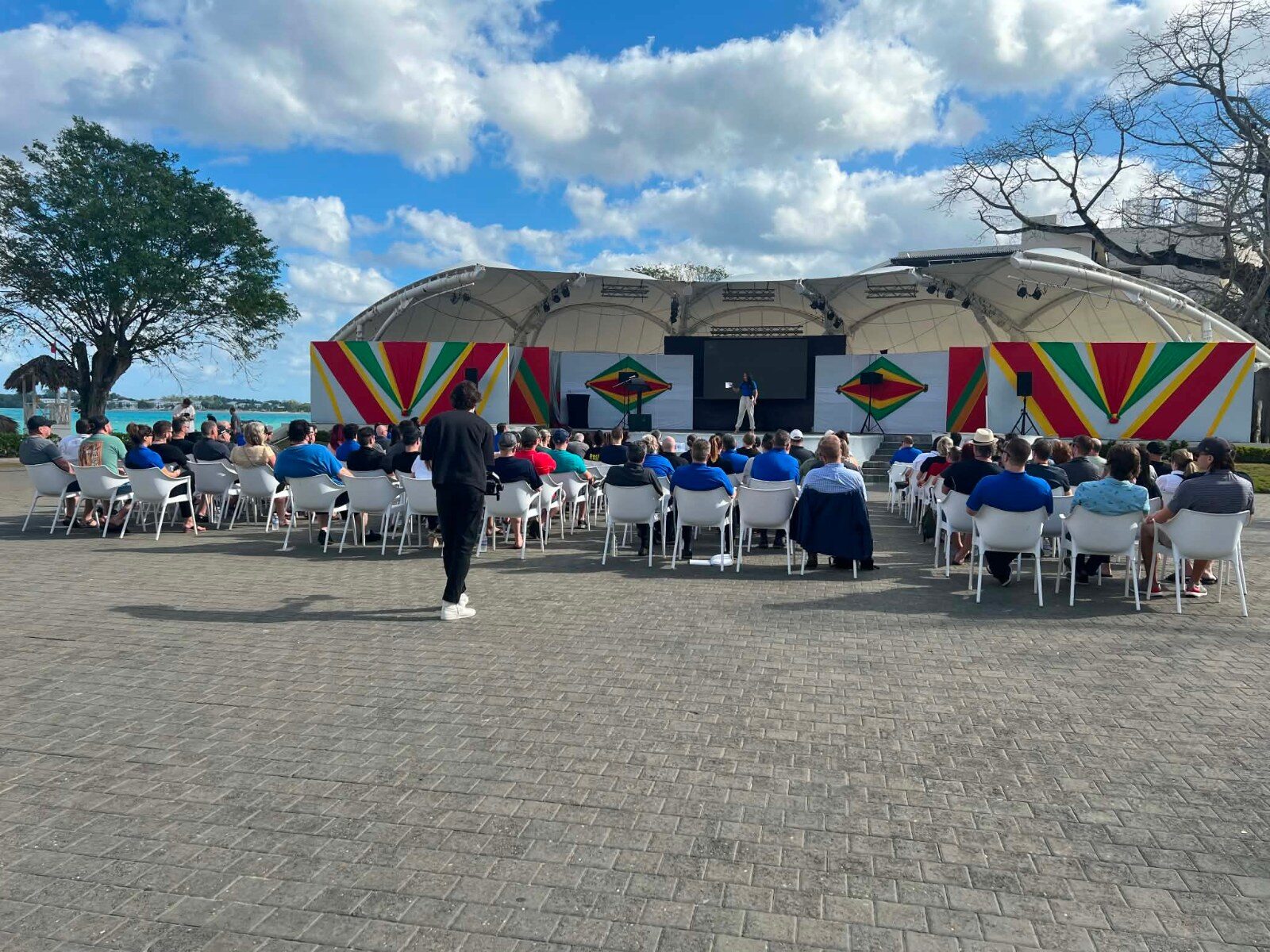 Participants seated facing the stage during an outdoor conference session
