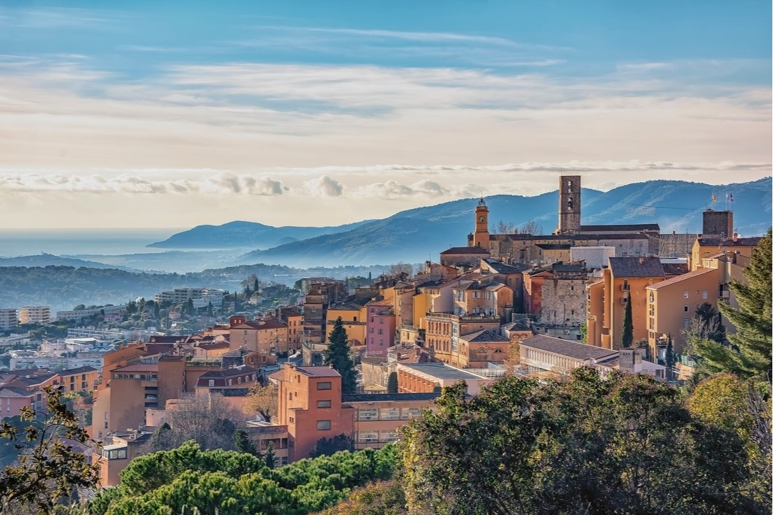 Orange-toned Provençal buildings at Club Med Opio with panoramic views of the green mountains in the background.