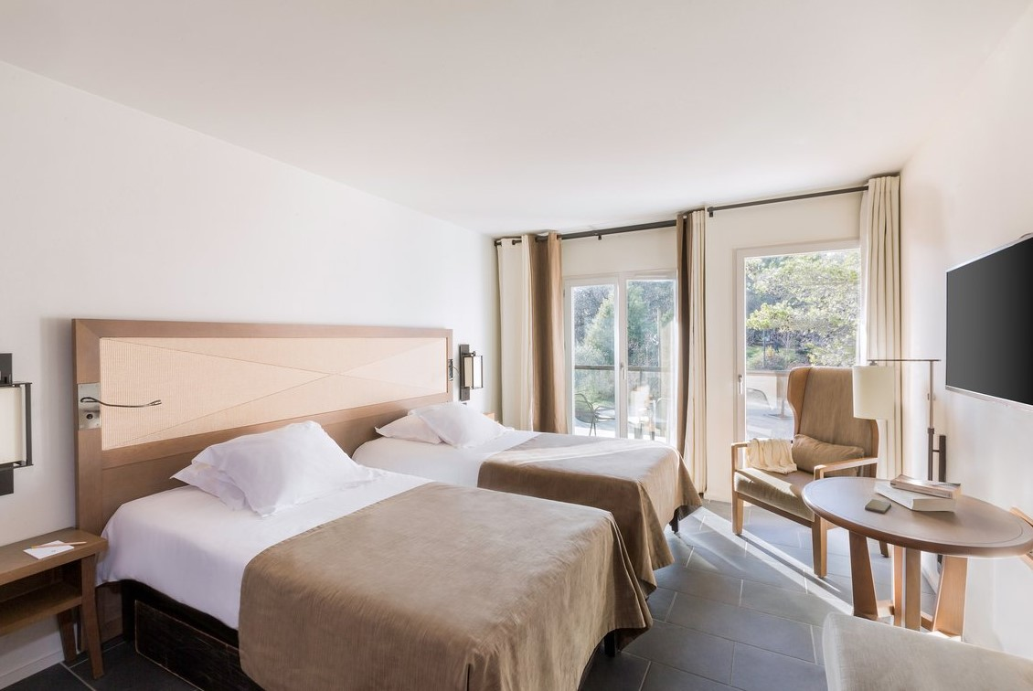 Chambre supérieure au Club Med Opio en Provence avec lits simples, balcon et vue sur un jardin privé pour un séjour relaxant.