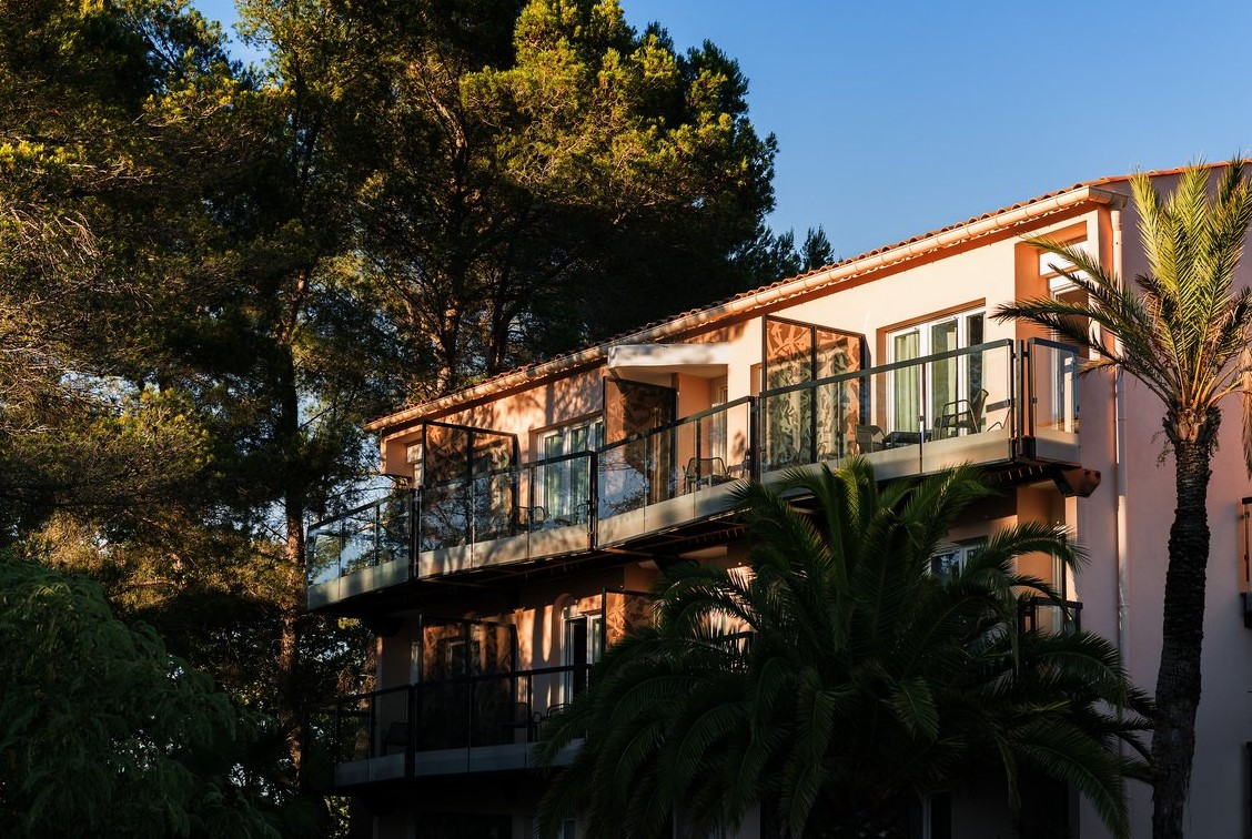 Façade des chambres avec balcons du Club Med Opio en Provence offrant une vue apaisante sur les arbres et la nature environnante.