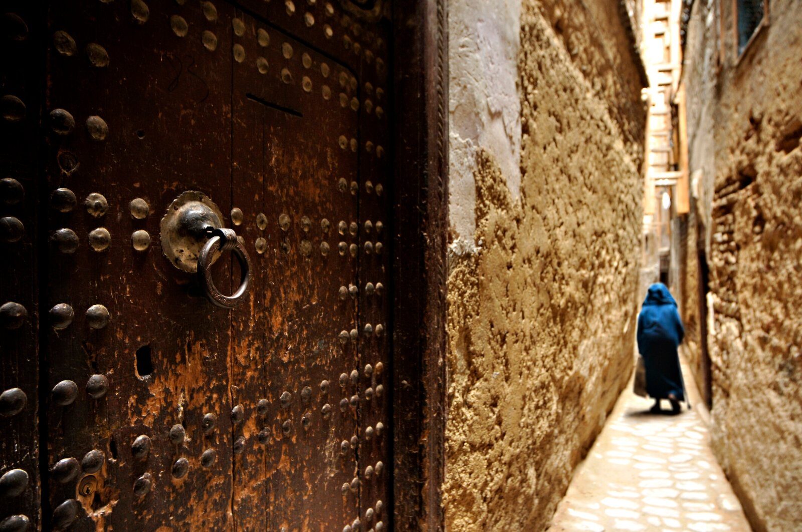 Porte cloutée dans une ruelle de médina au Maroc