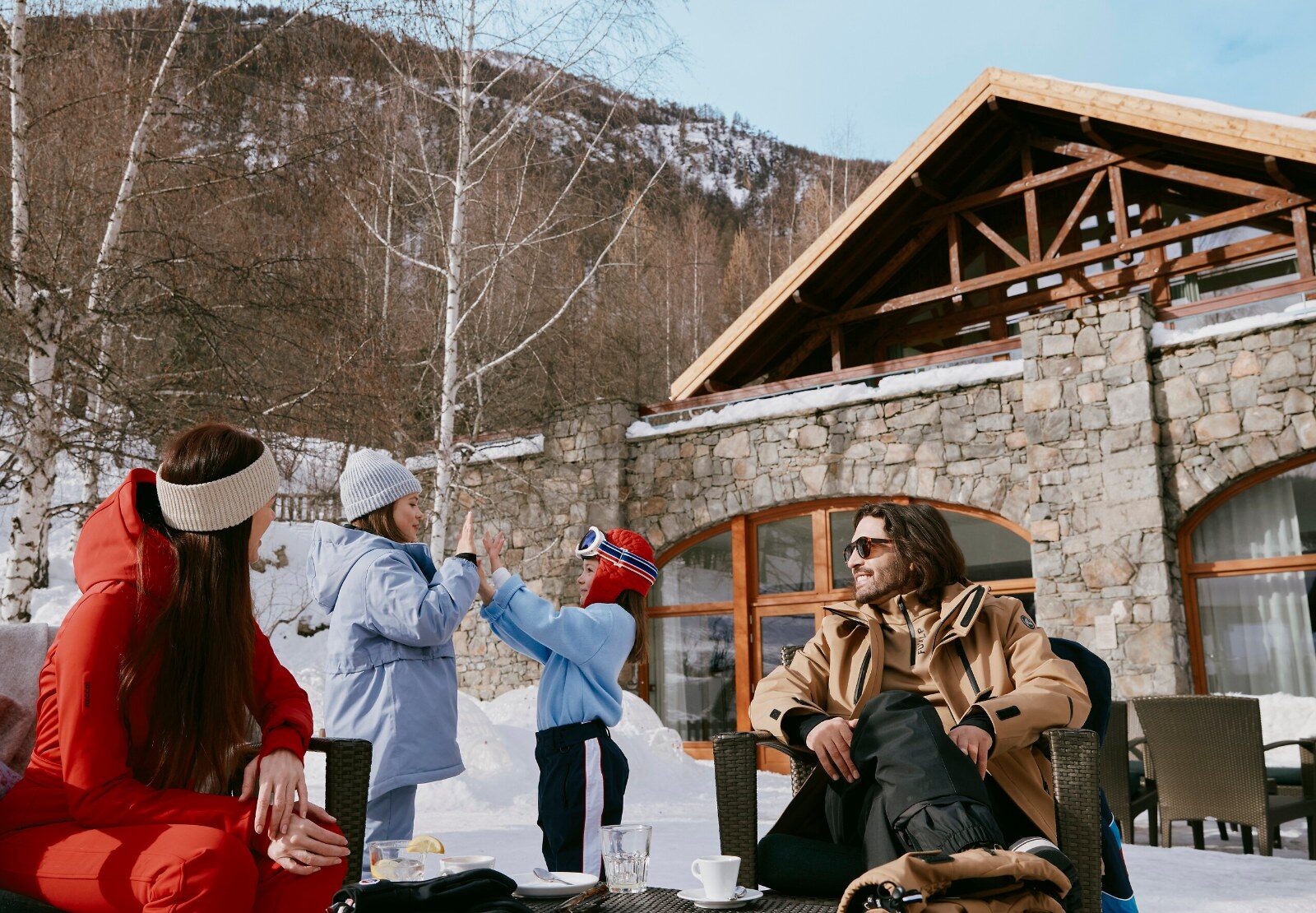 A family in front of a Club Med resort in the Alps
