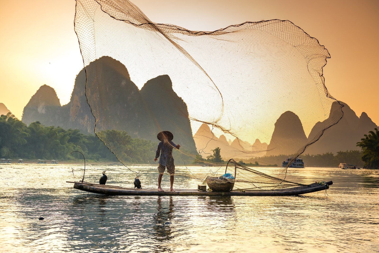 Pêcheur au coucher du soleil sur la rivière Li, près de Guilin