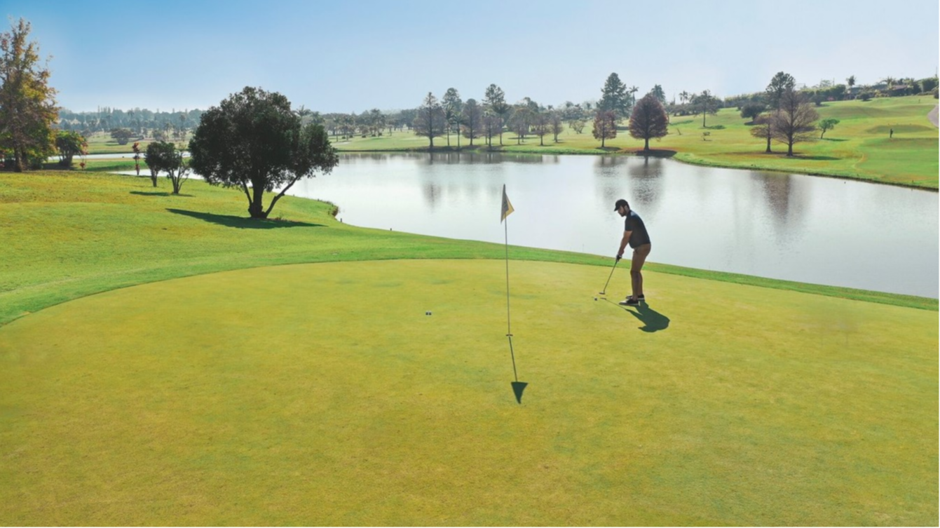 Homme jouant au golf sur le green au Club Med Lake Paradise, Brésil, entouré d