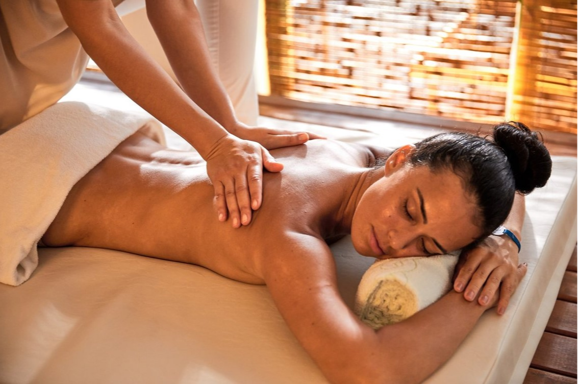 Femme recevant un massage relaxant au Club Med Lake Paradise, Brésil, dans un cadre apaisant et serein.