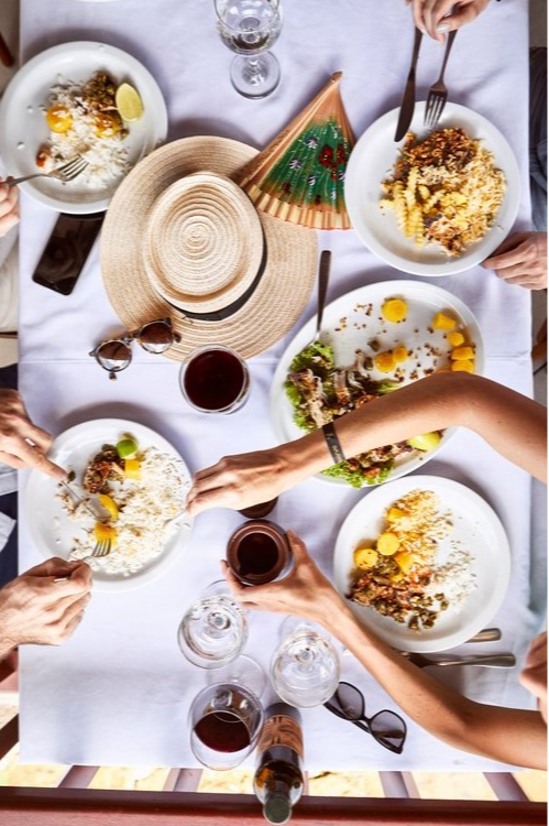 Outdoor dining table at Club Med Lake Paradise in Brazil, filled with delicious dishes and wine for a convivial meal.