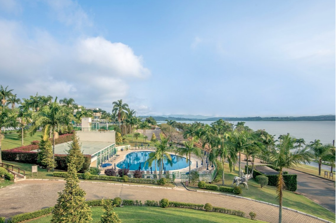 Vue aérienne de la piscine et salle de sport vitrée au Club Med Lake Paradise, Brésil, avec vue sur le lac et le resort.