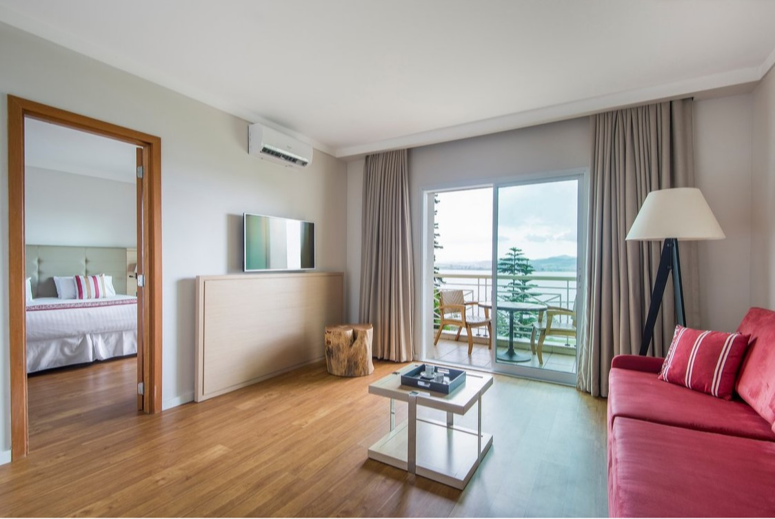 Suite elegant living room at Club Med Lake Paradise in Brazil, with a sofa, coffee table, and a view of the surrounding nature.