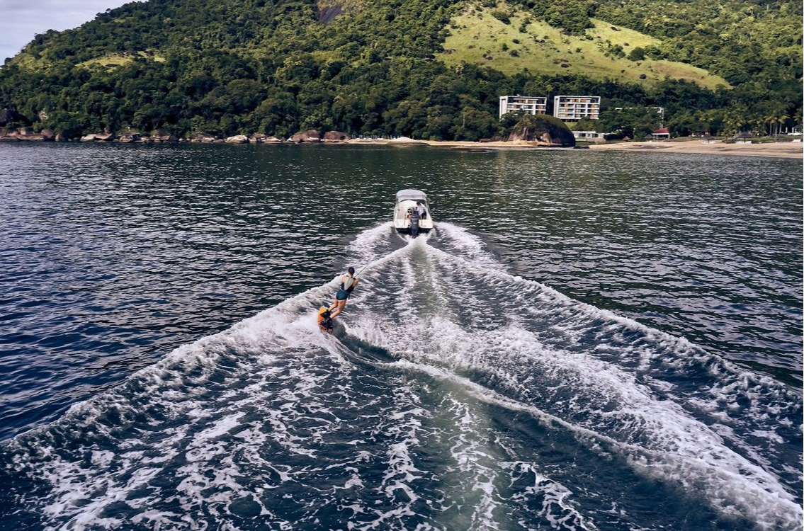 Woman wakeboarding on the blue waves of the Atlantic Ocean at Club Med Rio Das Pedras. An unforgettable aquatic adventure.