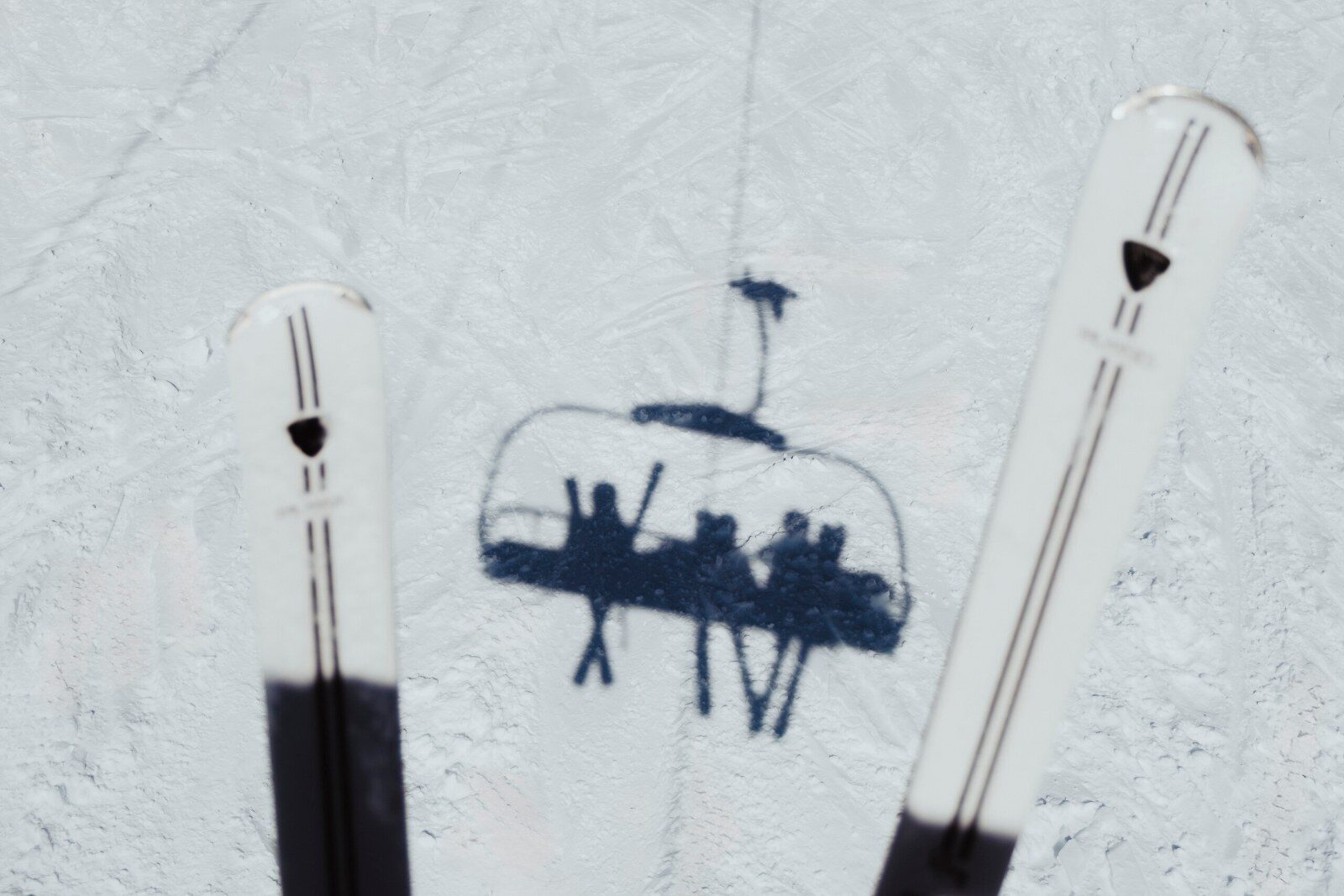 The shadow of a chairlift on the snow