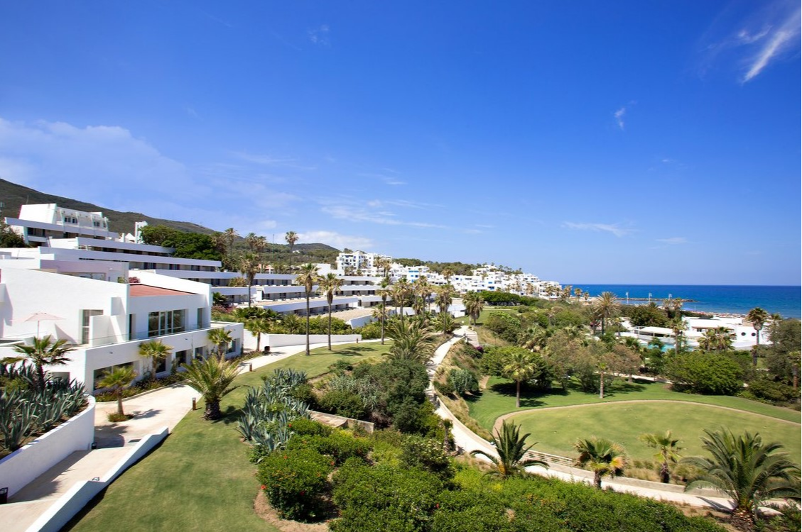 Vue panoramique du Club Med Yasmina, avec les montagnes en arrière-plan et une vue imprenable sur la Méditerranée.