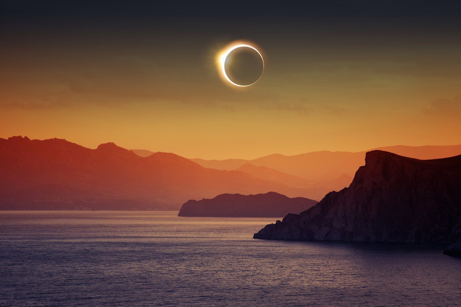 Éclipse totale de soleil au-dessus de la mer et des falaises