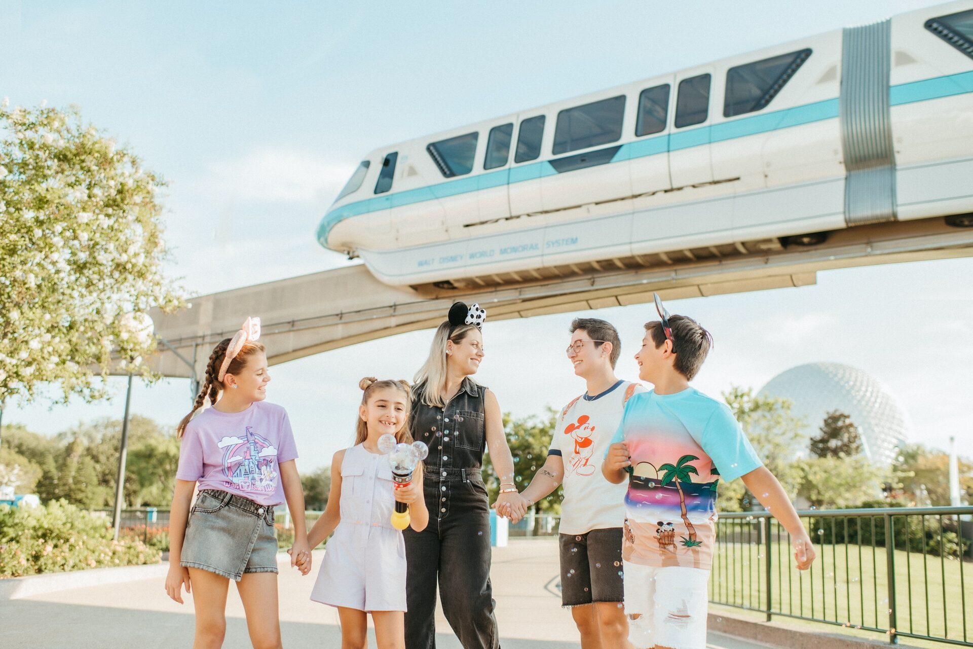 Une famille marche sous le monorail de Walt Disney World, près de l’entrée d’EPCOT, en Floride