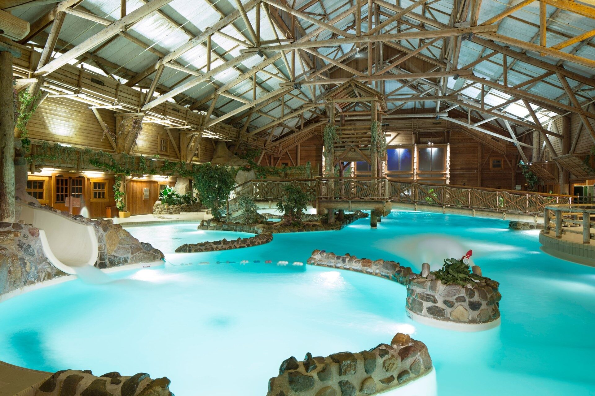 La Blue Springs Pool du Disney Davy Crockett Ranch, une piscine intérieure aux allures de lagon, entre rochers et charpente de bois. Photo : ©Disney.