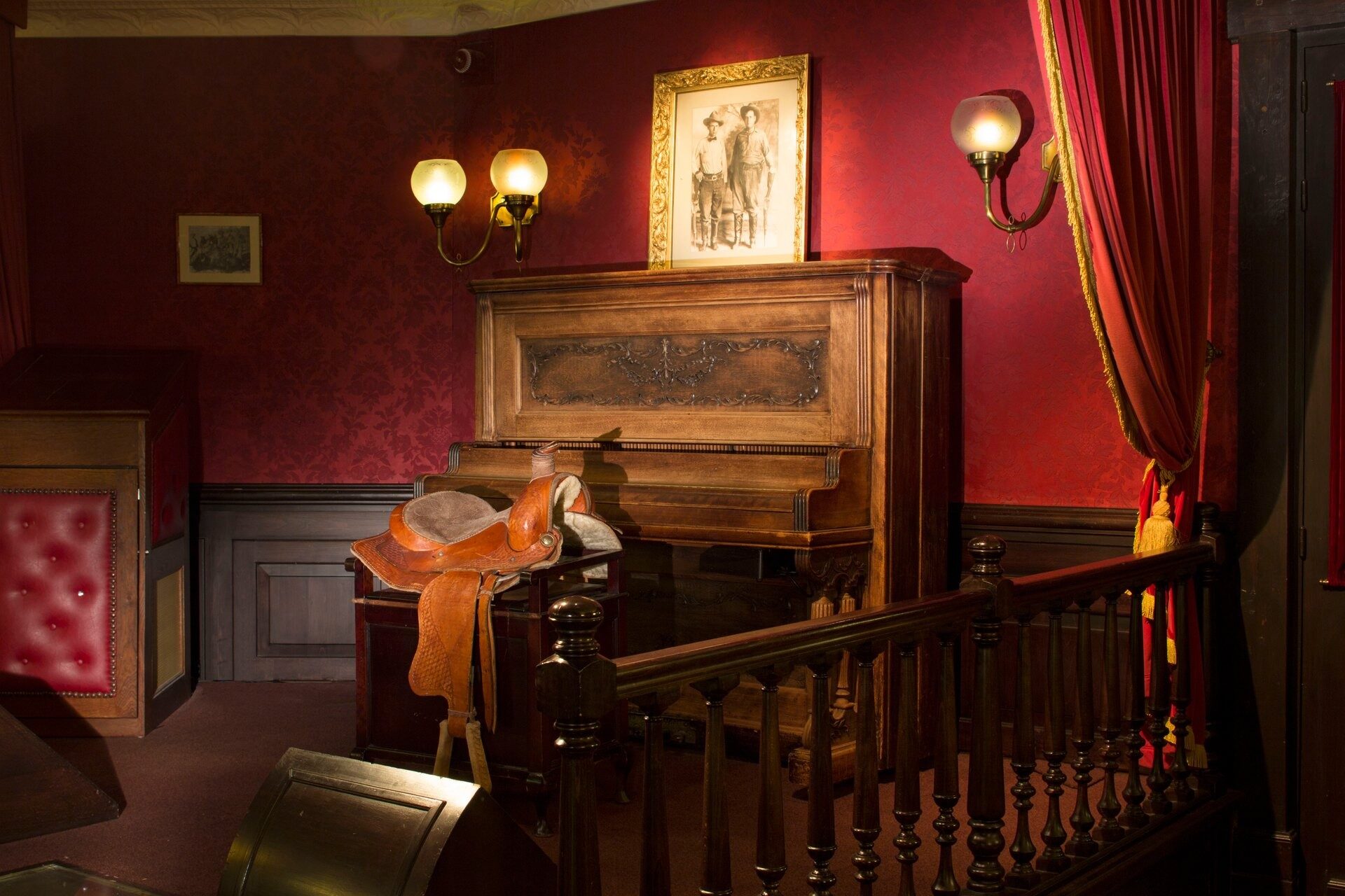 Le Red Garter Saloon du Disney Hotel Cheyenne, avec son vieux piano, sa selle de cuir et ses rideaux de velours rouge. Photo : ©Disney.