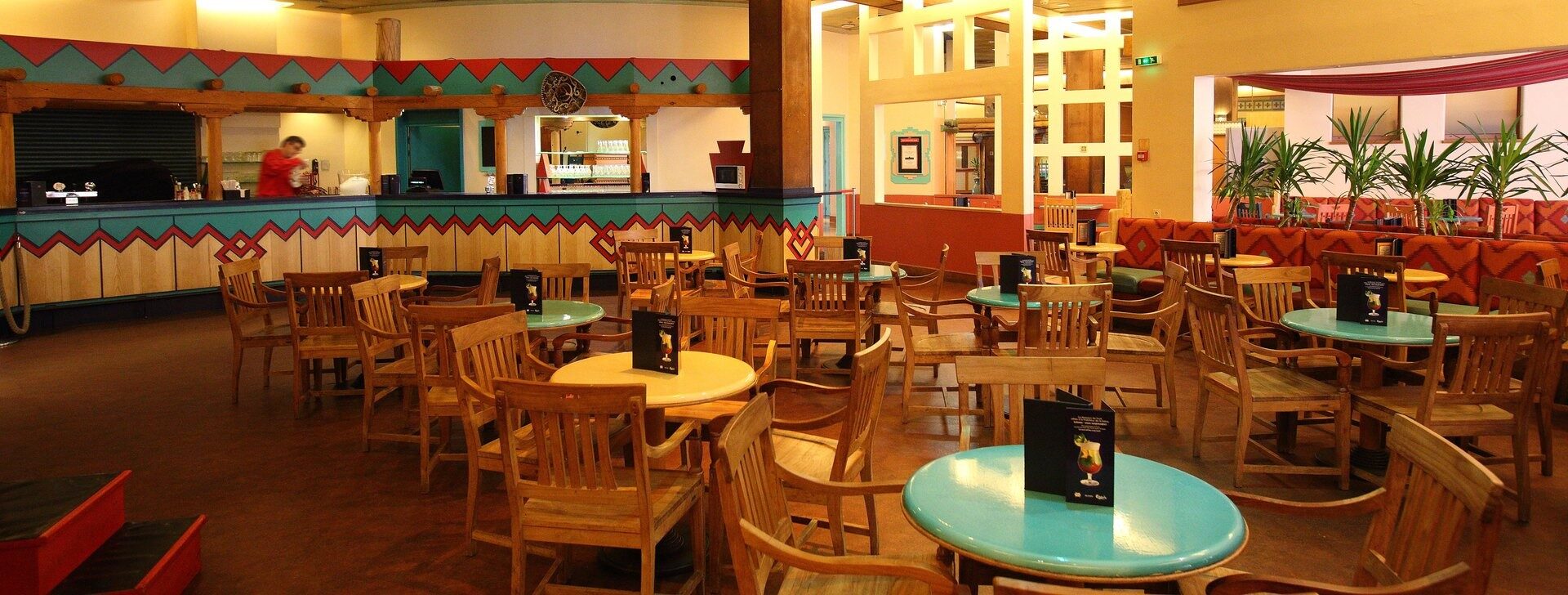 Le Rio Grande Bar du Disney Hotel Santa Fe, une grande salle aux couleurs du Sud-Ouest américain avec ses tables rondes turquoise. Photo : ©Disney.