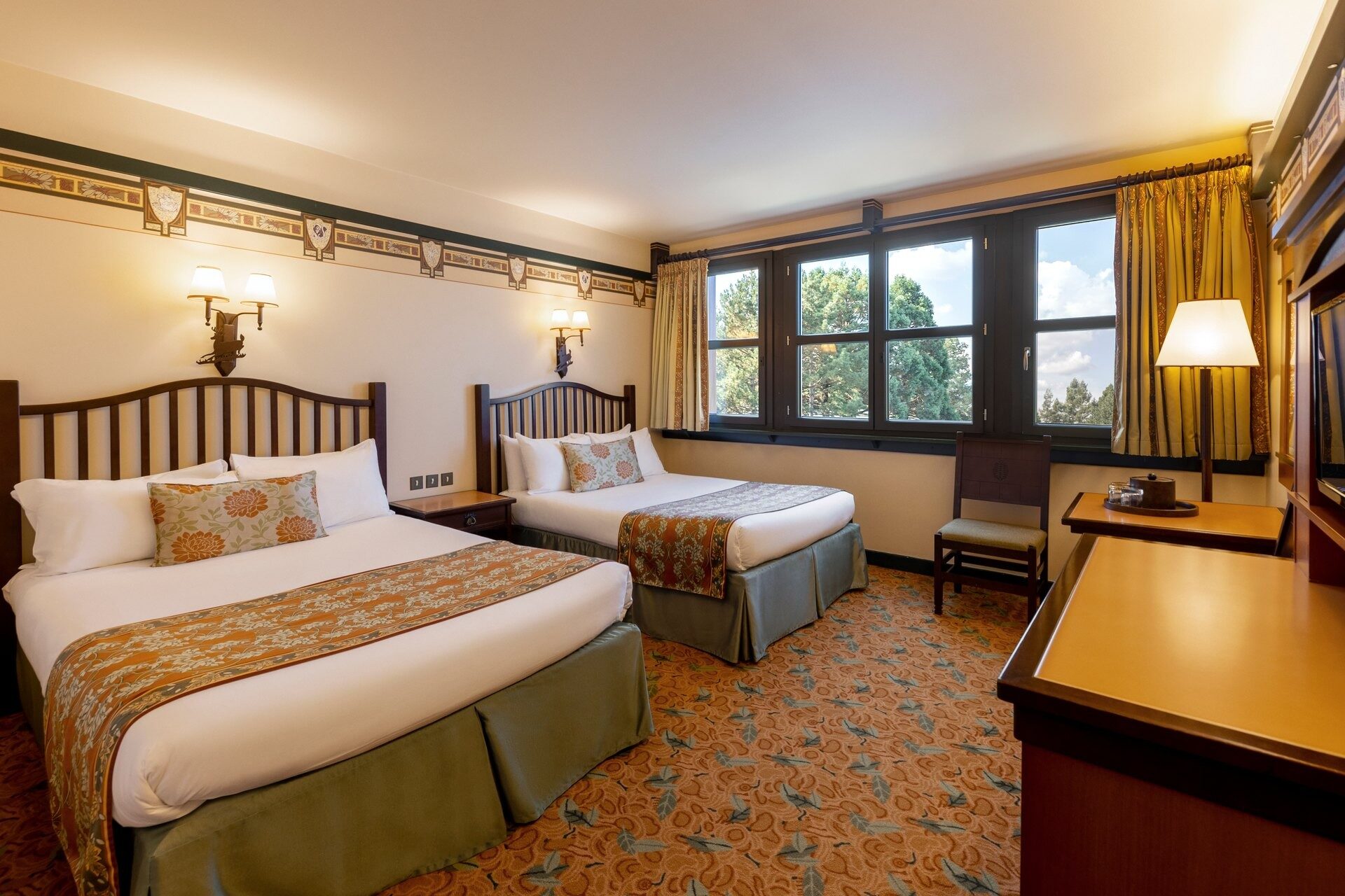Une chambre Standard du Disney Sequoia Lodge, avec deux grands lits, des boiseries et des fenêtres ouvertes sur les arbres. Photo : ©Disney.