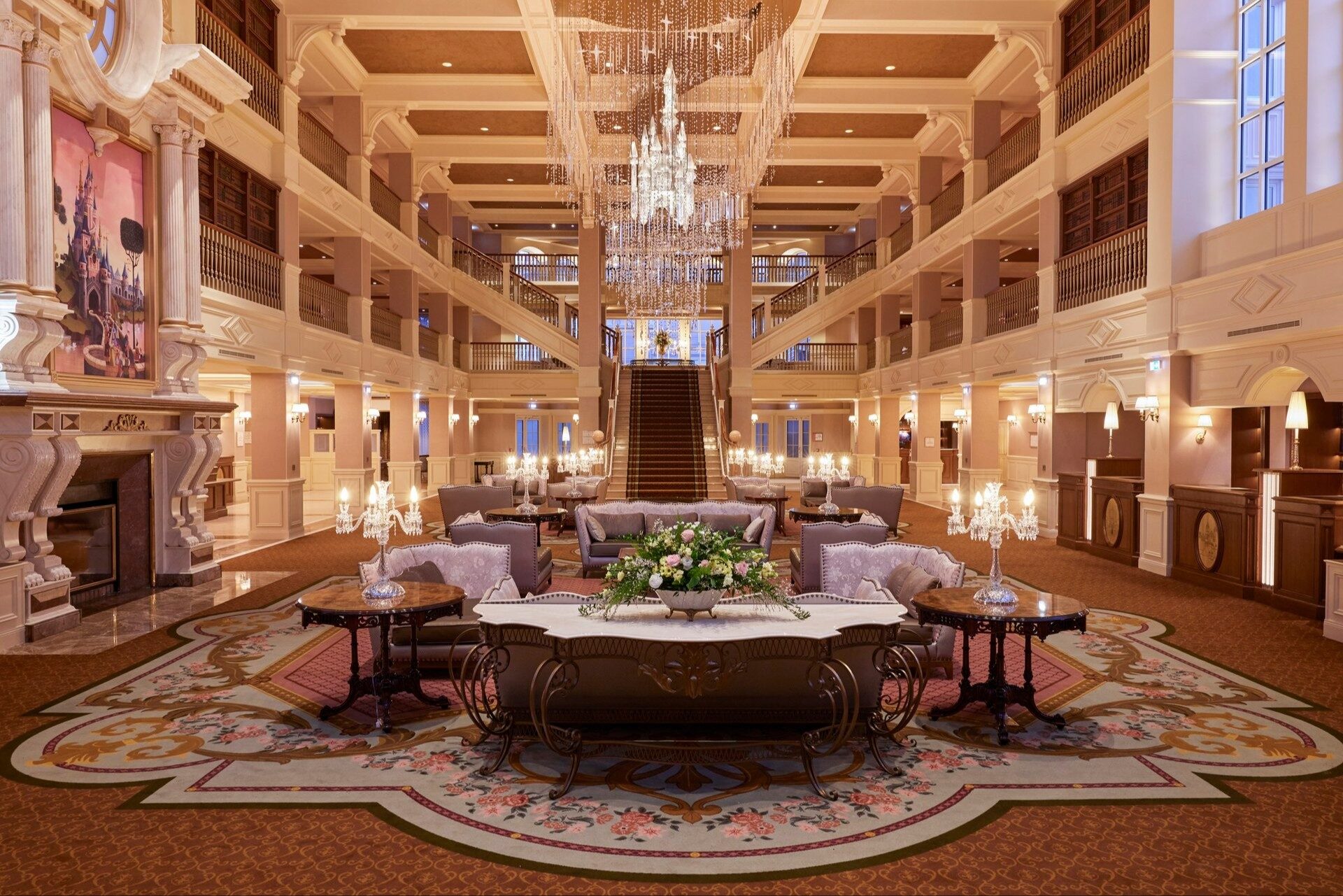 The grand lobby of Disneyland Hotel at Disneyland Paris, with crystal chandeliers, balconies on several floors and a central staircase. Photo: ©Disney.