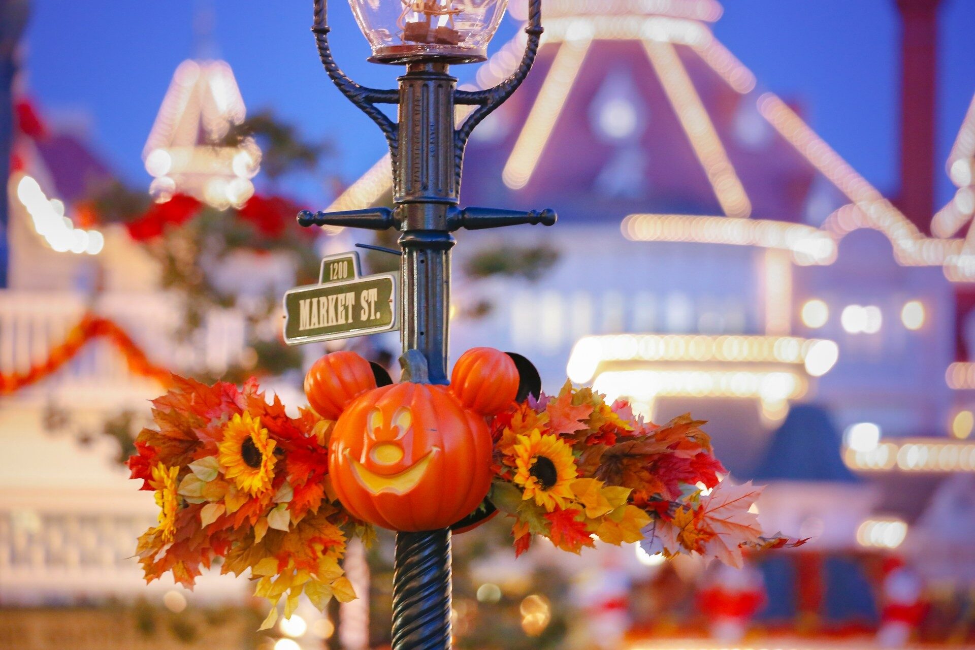 A Mickey-shaped pumpkin and sunflowers decorate a lamp post on Main Street, U.S.A. during the Disney Halloween Festival. Photo: ©Disney.