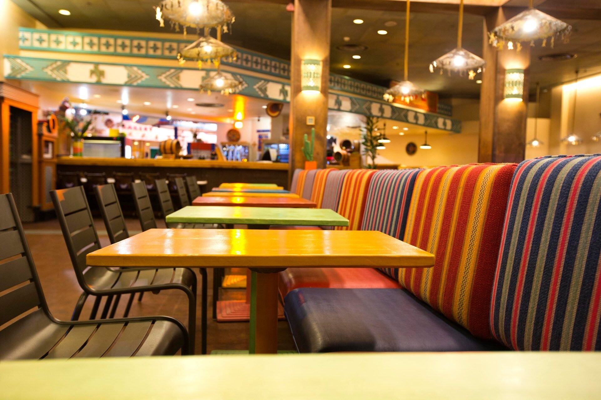La salle de La Cantina, au Disney Hotel Santa Fe, avec ses banquettes aux rayures vives et ses tables jaunes. Photo : ©Disney.