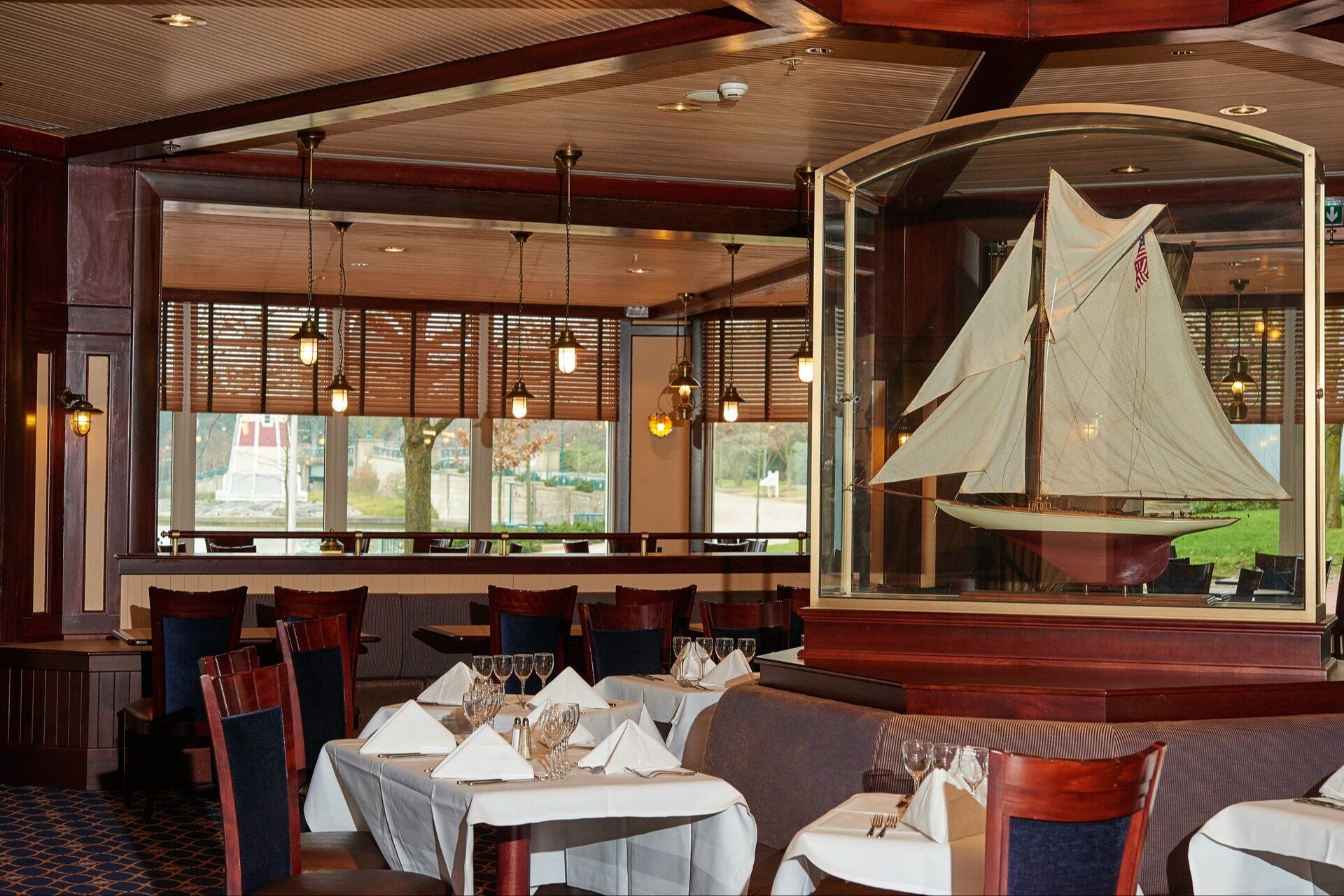 La salle lambrissée du Yacht Club, au Disney Newport Bay Club, avec une maquette de voilier sous verre au centre.
