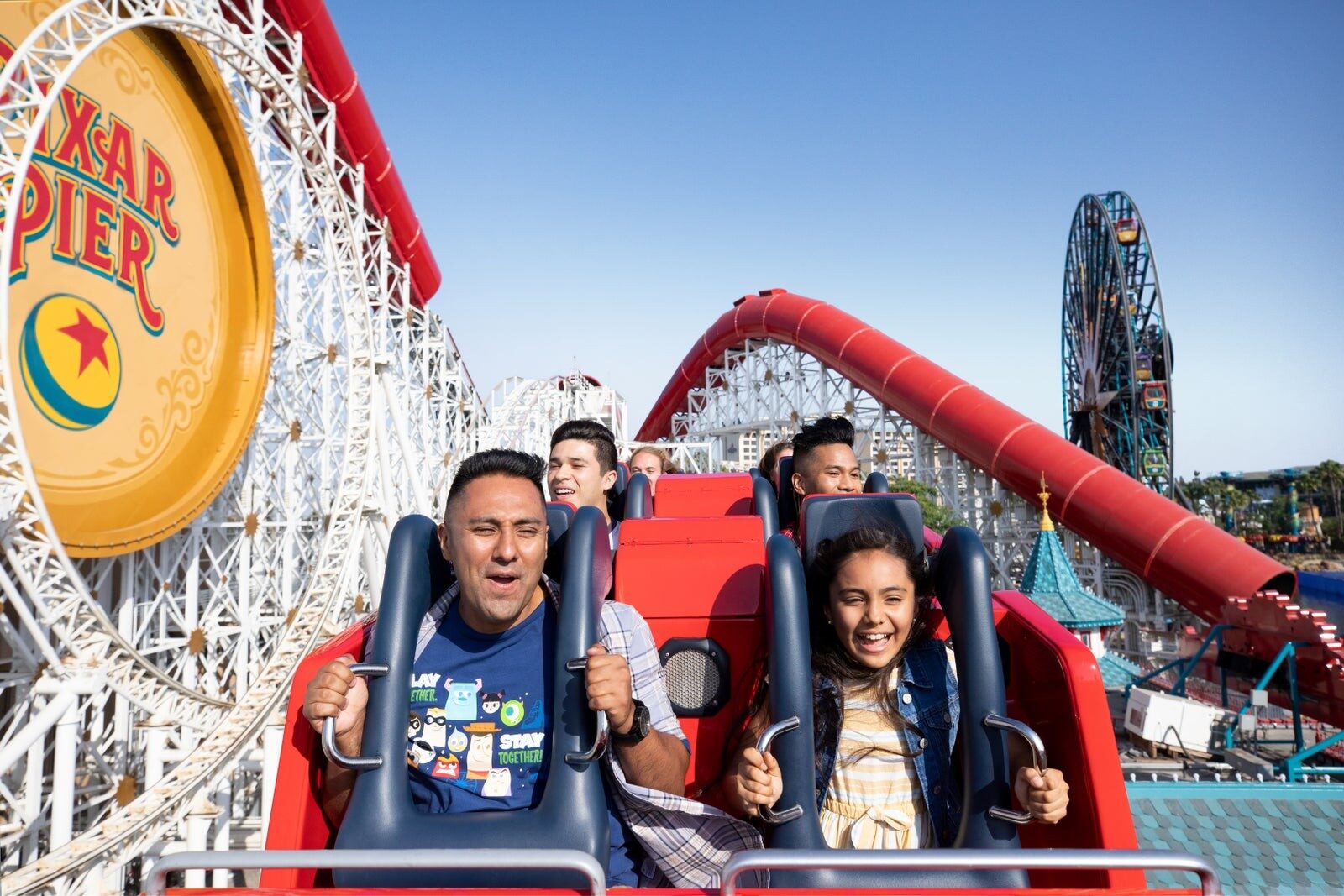 Guests riding the Incredicoaster at Pixar Pier