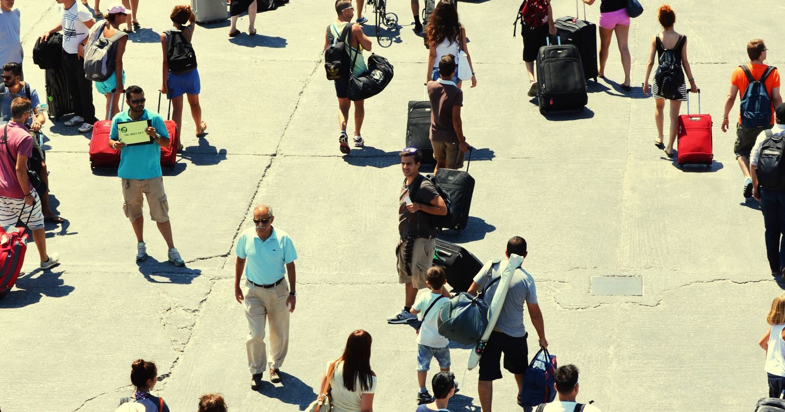 Passagers marchant vers le terminal avec leurs valises le jour de l'embarquement d'une croisière