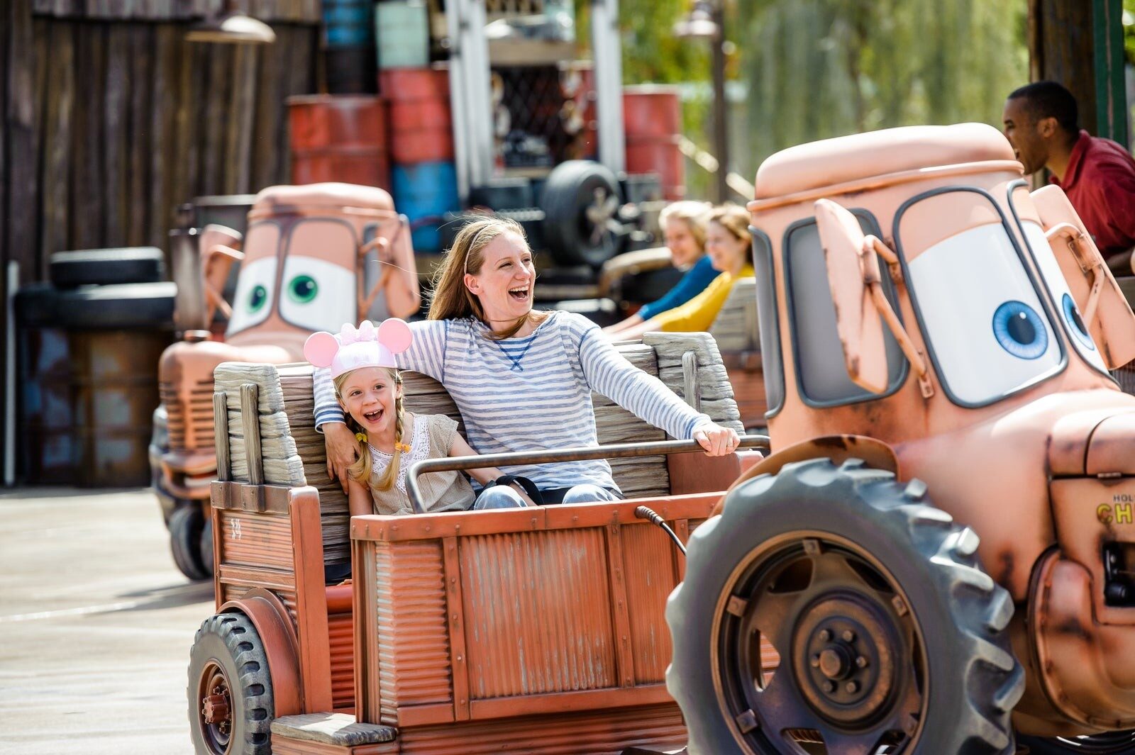 Une mère et sa fille rient à bord de Mater's Junkyard Jamboree, à Cars Land