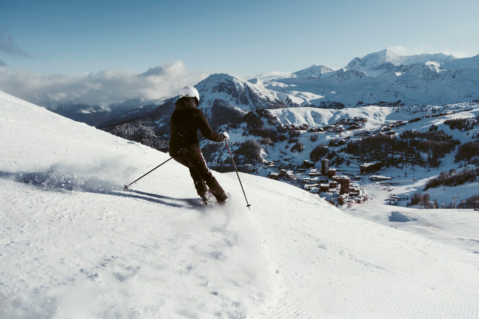 Skieur sur une piste face aux sommets des Alpes Skieur sur une piste face aux sommets des Alpes