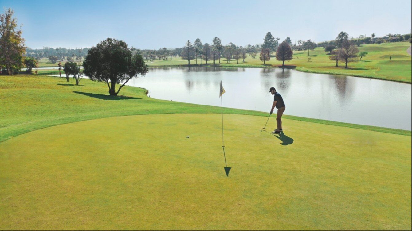 Golfeur sur un green au bord du lac au Club Med Lake Paradise Golfeur sur un green au bord du lac au Club Med Lake Paradise
