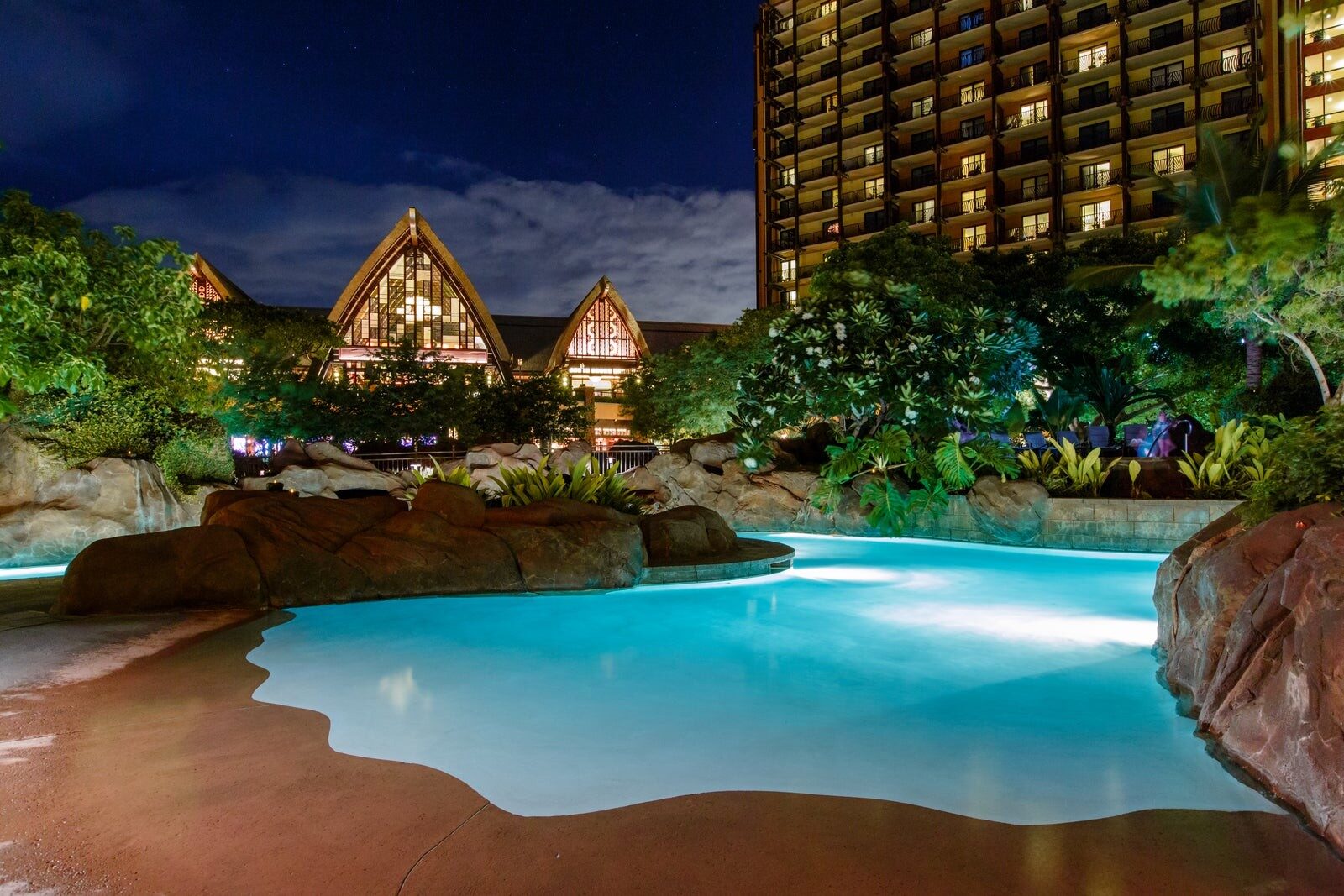 The Waikolohe Valley pool lit up at nightfall at Aulani